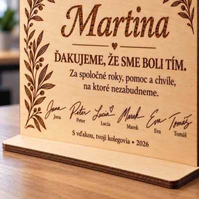 Darček pre kolegu na rozlúčku s menami a podpismi na pracovnom stole
